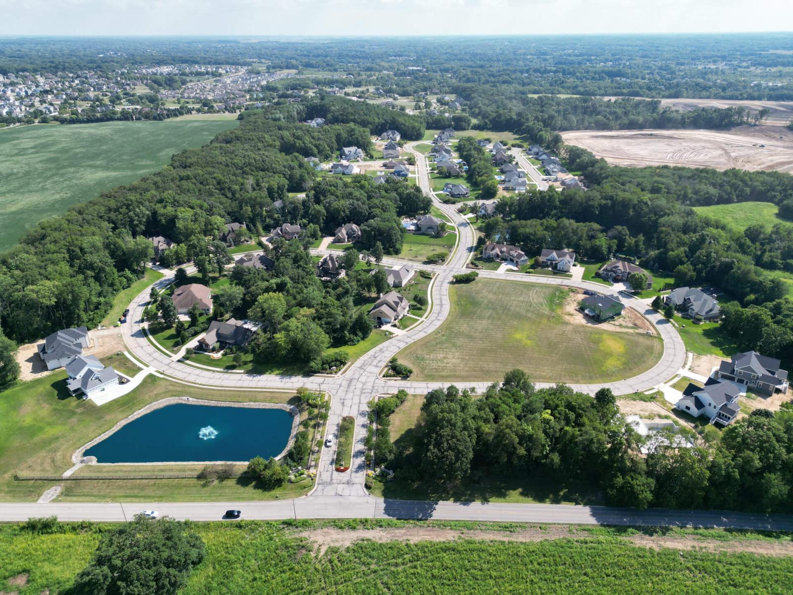 Aerial view of Brigata Hills with the community pond and curving streets